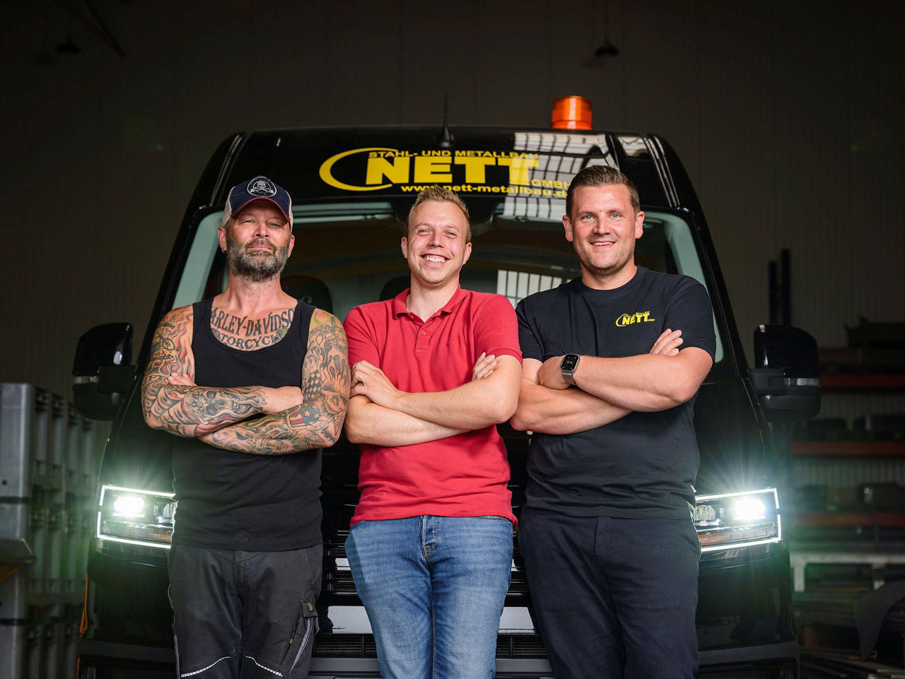 Drei Männer stehen vor ihrem MAN TGE. Das ist ein Teil des Teams der Firma Nett. 